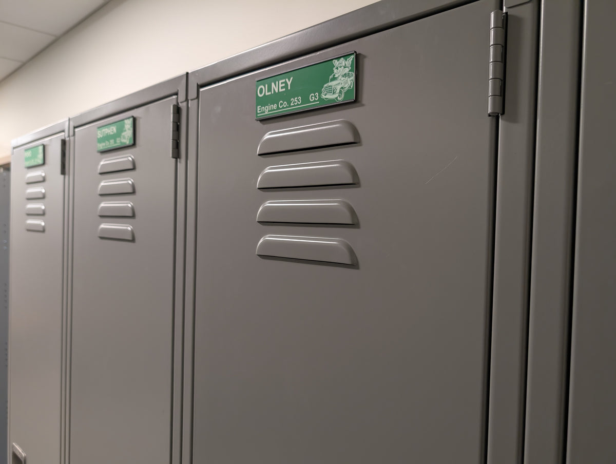 Personalized gear locker nameplates installed on fire station lockers